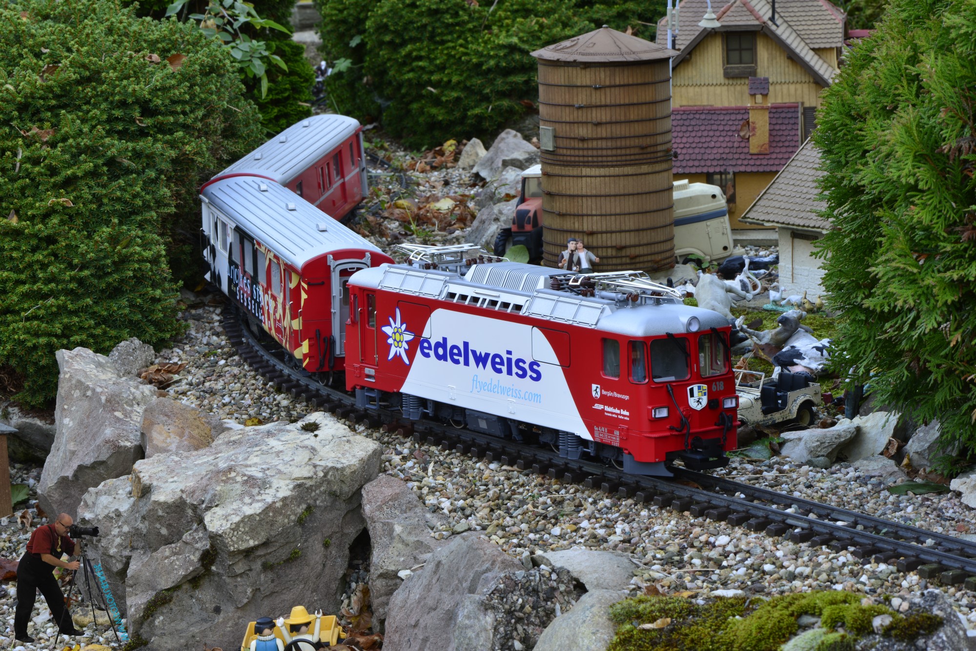 Unterwegs vor dem Bauernhof in Bumblebee-Valley die Werbelok "edelweiss - flyedelweiss.com" der RhB Ge 4/4 II Nr. 618 - Bergn